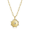 Gold necklace with a sunburst pendant on a white background